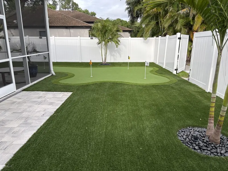 Backyard putting green with artificial turf lawn and paver patio