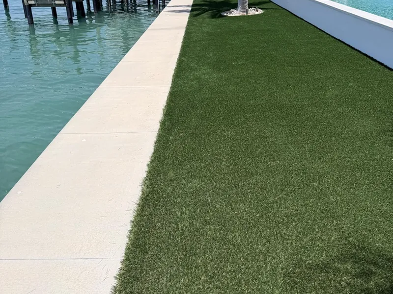 Bayfront artificial grass lawn between the seawall and pool