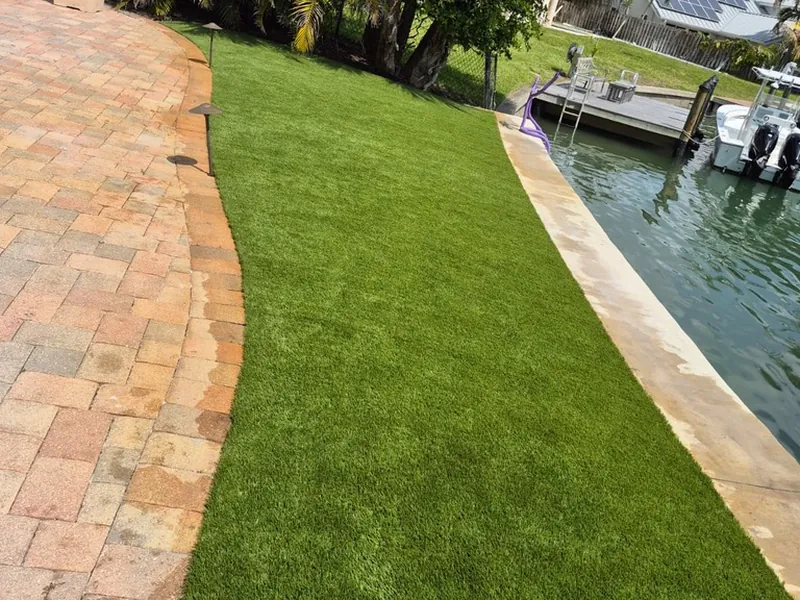 Canal-front artificial grass lawn along the seawall with paver border