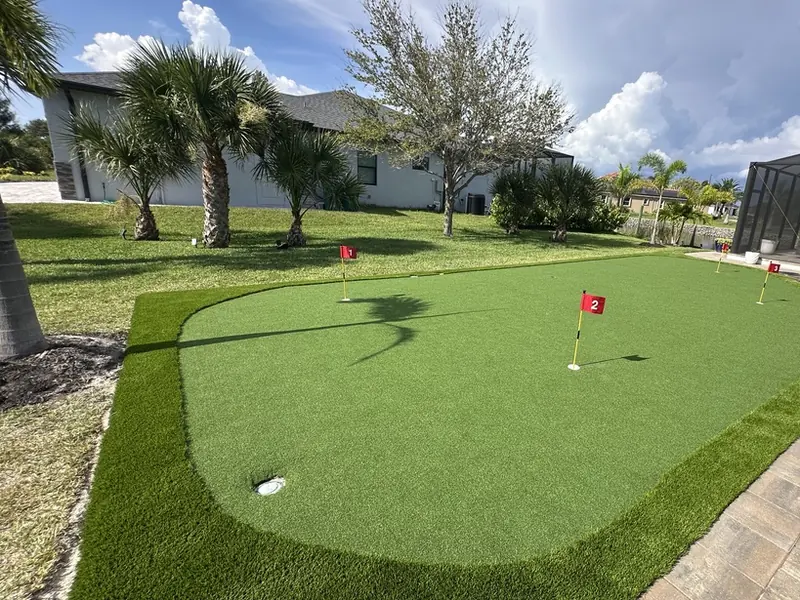 Five-cup backyard putting green with paver border in Charlotte County FL