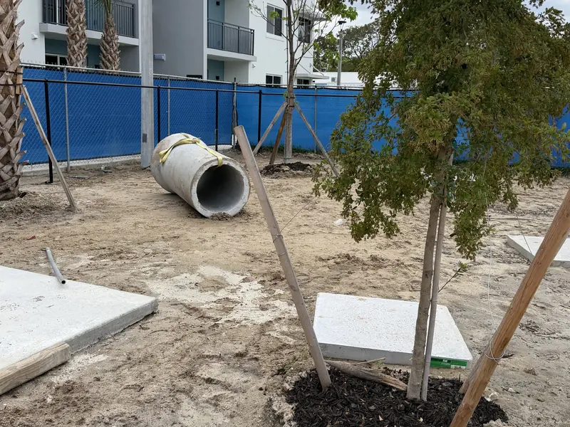 Before: sandy dog park area at an apartment community in East Naples FL