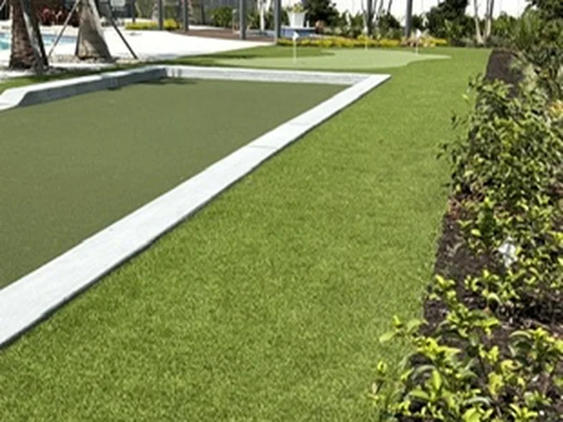 Naples community amenity bocce court with turf, pergola and landscape beds
