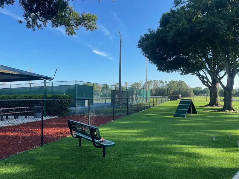 Sarasota community dog park with pet turf, agility ramp and benches by Creative Grounds
