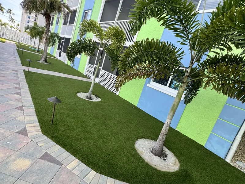 Condo courtyard with artificial grass, palms and landscape lighting