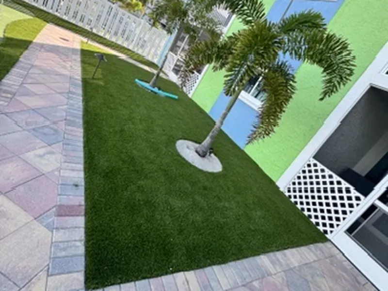 Condo artificial grass lawn along a paver walkway
