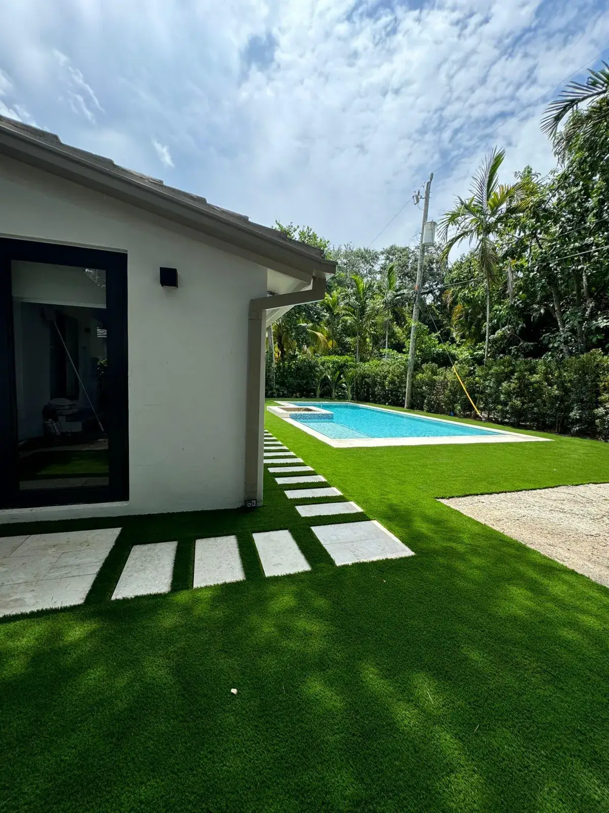 Pool pavers and stepping stones with turf in Coral Gables, FL by Creative Grounds