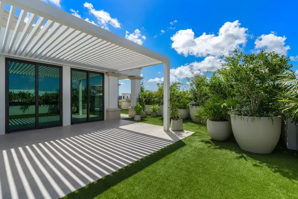 Artificial turf and potted landscape under a pergola by Creative Grounds in Coral Gables