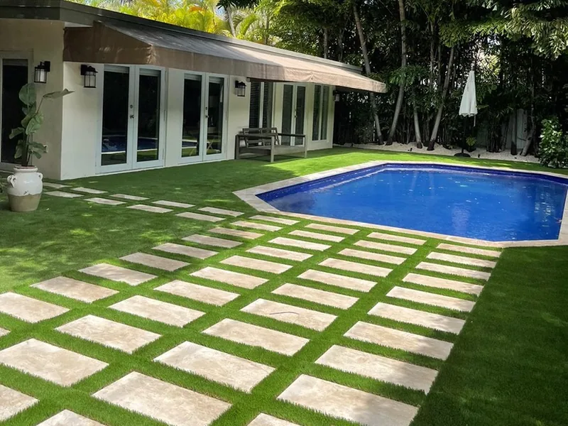 Courtyard pool with a grid of stepping pads set in artificial turf