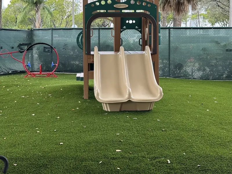 Toddler slide on playground turf at a Doral daycare