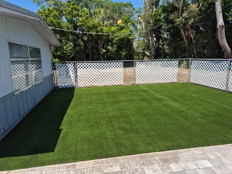 Fenced backyard with new artificial grass lawn
