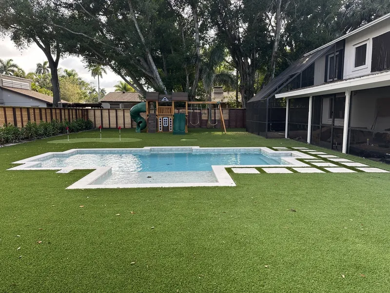 Fort Myers backyard with pool, artificial turf, putting green and playset