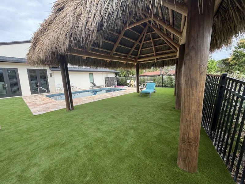 Artificial turf under a tiki hut beside a pool in Fort Myers
