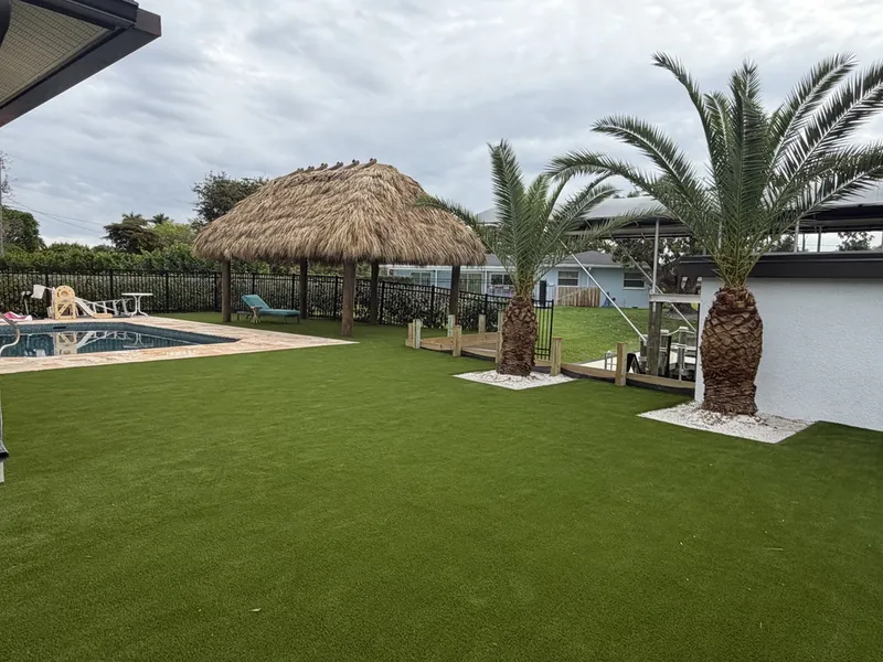 Artificial grass with tiki hut and palms beside a Fort Myers pool