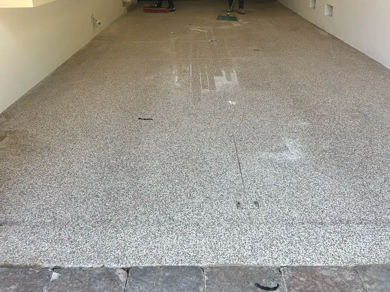 Before: bare garage floor in a Sarasota golf simulator room