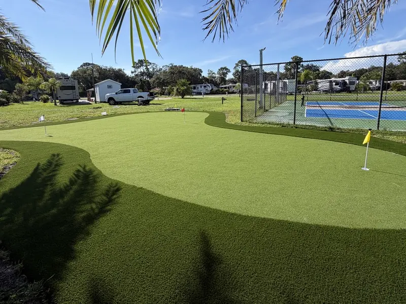 Community putting green next to pickleball courts in LaBelle FL