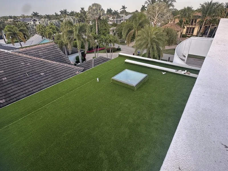 Rooftop artificial grass lawn with skylight overlooking palms in Naples