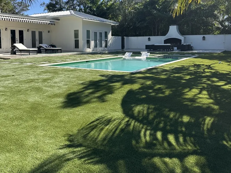 Artificial grass lawn by the pool and cabana in Naples