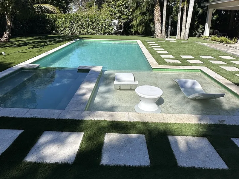 Sun shelf pool with artificial turf and stepping pads in Naples