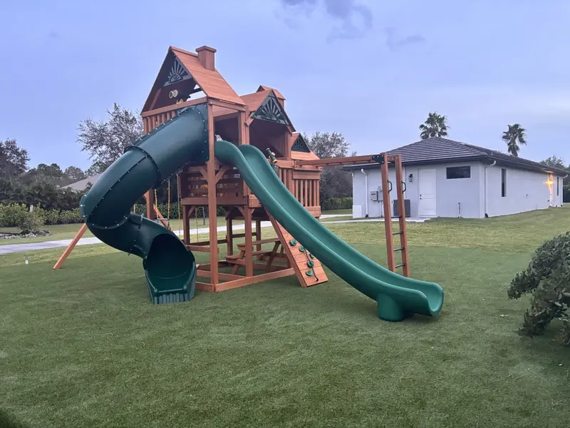 Playset with tube slide on artificial turf in Naples FL
