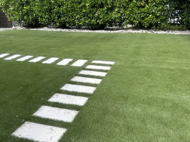 Artificial grass lawn with stepping stones along a hedge in Naples
