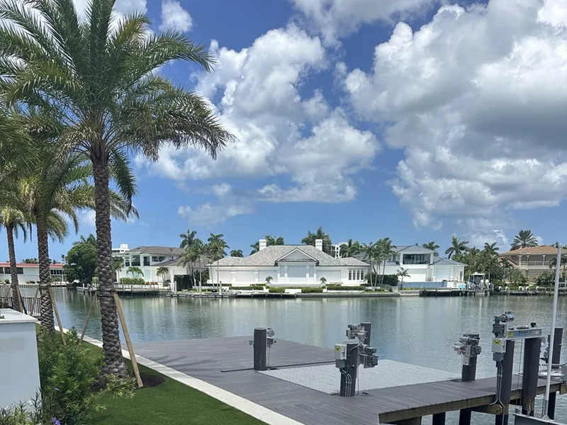 Naples waterfront turf lawn beside a boat lift and dock
