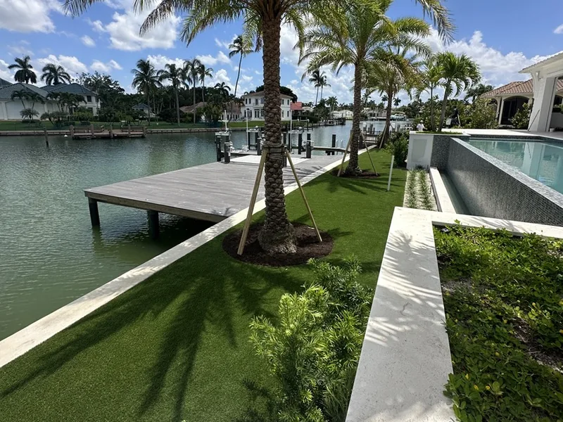 Naples waterfront artificial grass lawn with palms, dock and pool