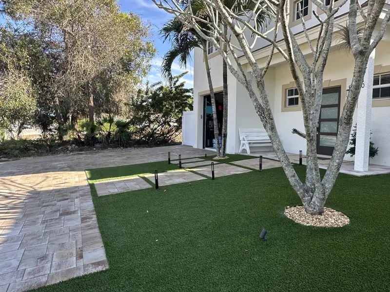 Front yard turf and tree ring by Creative Grounds at the Pink House in Bonita Springs FL