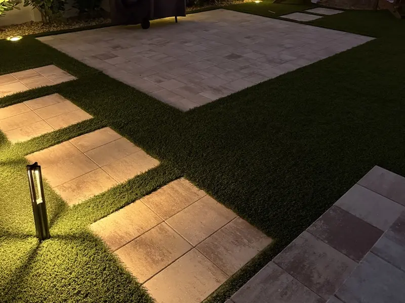Path lights glowing along travertine stepping stones and artificial turf at night, Bonita Springs