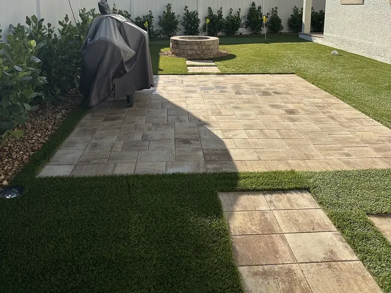 Paver patio framed by turf by Creative Grounds at the Pink House in Bonita Springs FL