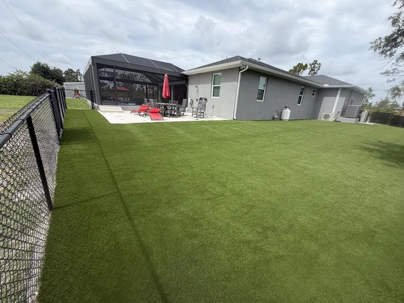 Wide fenced artificial grass backyard in Port Charlotte