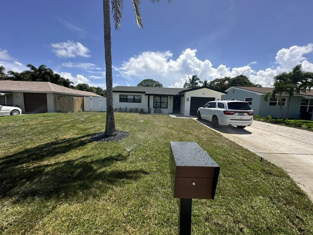 Freshly installed real sod front yard with sprinklers watering it in