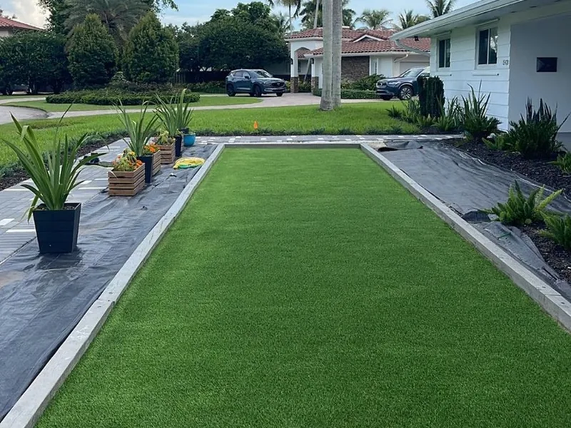 Residential artificial turf bocce court with palm tree in Palmetto Bay, FL