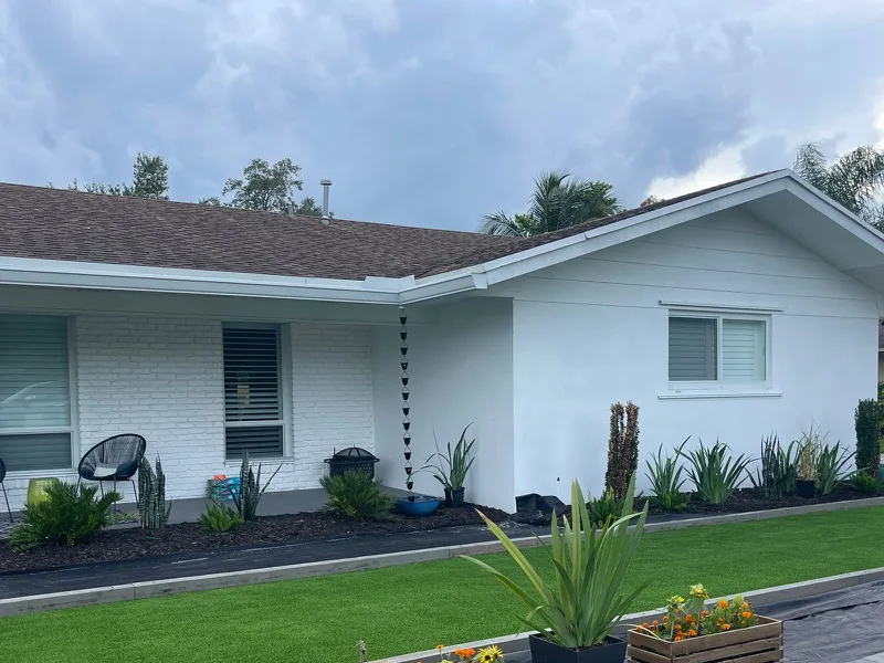 Artificial turf bocce court in front of a modern white home in Palmetto Bay