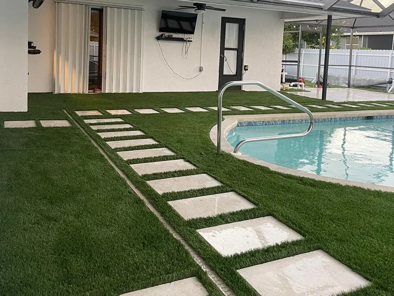 Stepping pads and linear drain set in artificial turf under a lanai