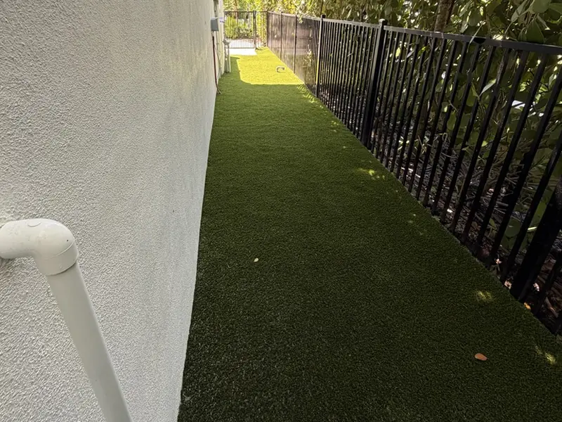 Pet turf dog run along a fenced side yard in Naples FL
