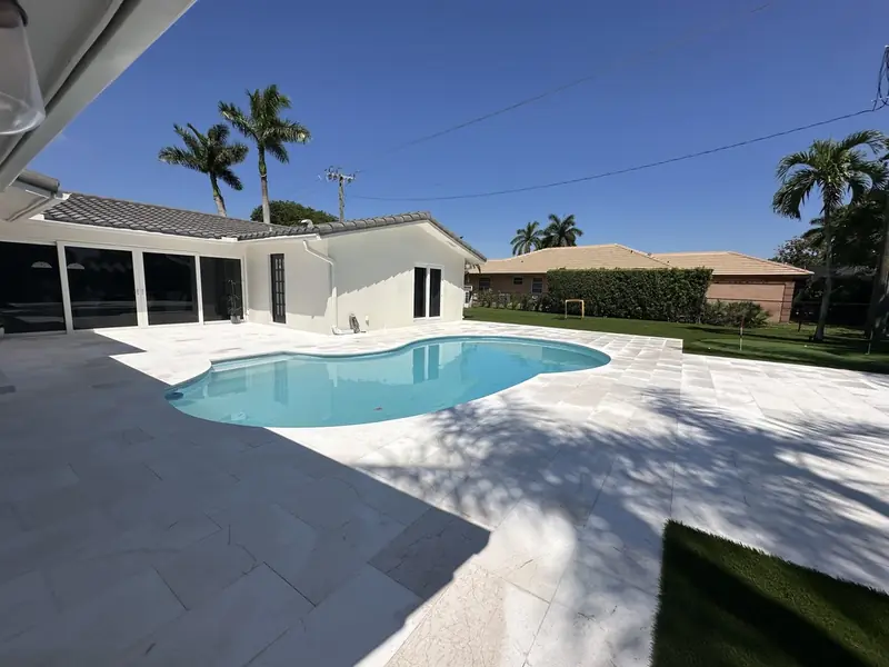 After: Travertine pool deck installed by Creative Grounds
