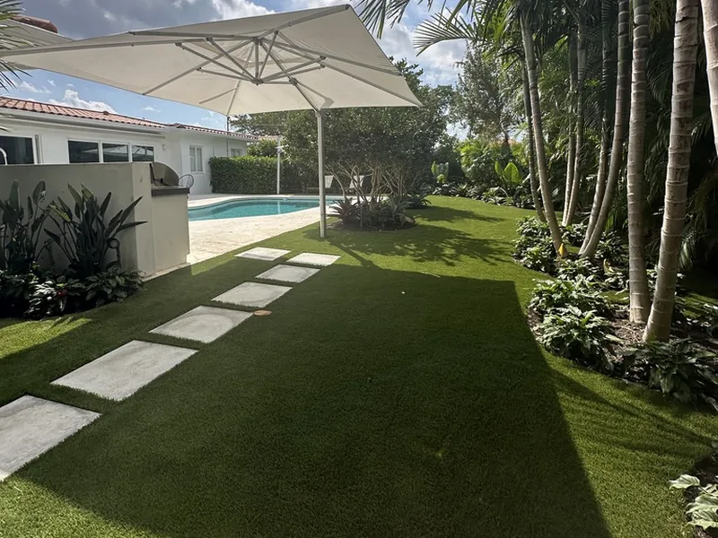 Stepping pads in artificial turf leading to the pool and umbrella